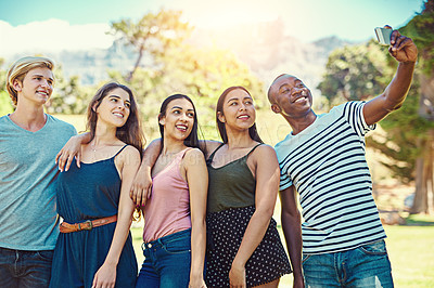 Buy stock photo Cropped shot of a group of young friends taking a selfie together at the park