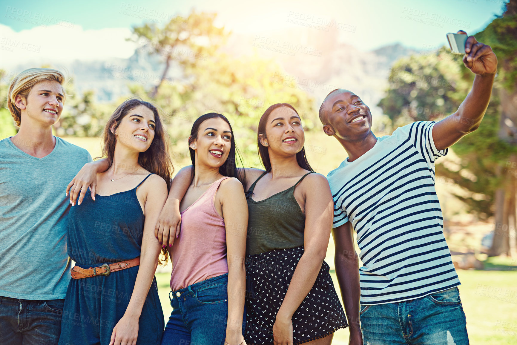 Buy stock photo Cropped shot of a group of young friends taking a selfie together at the park