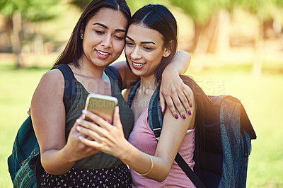 Buy stock photo Cropped shot of two young friends taking a selfie together outside