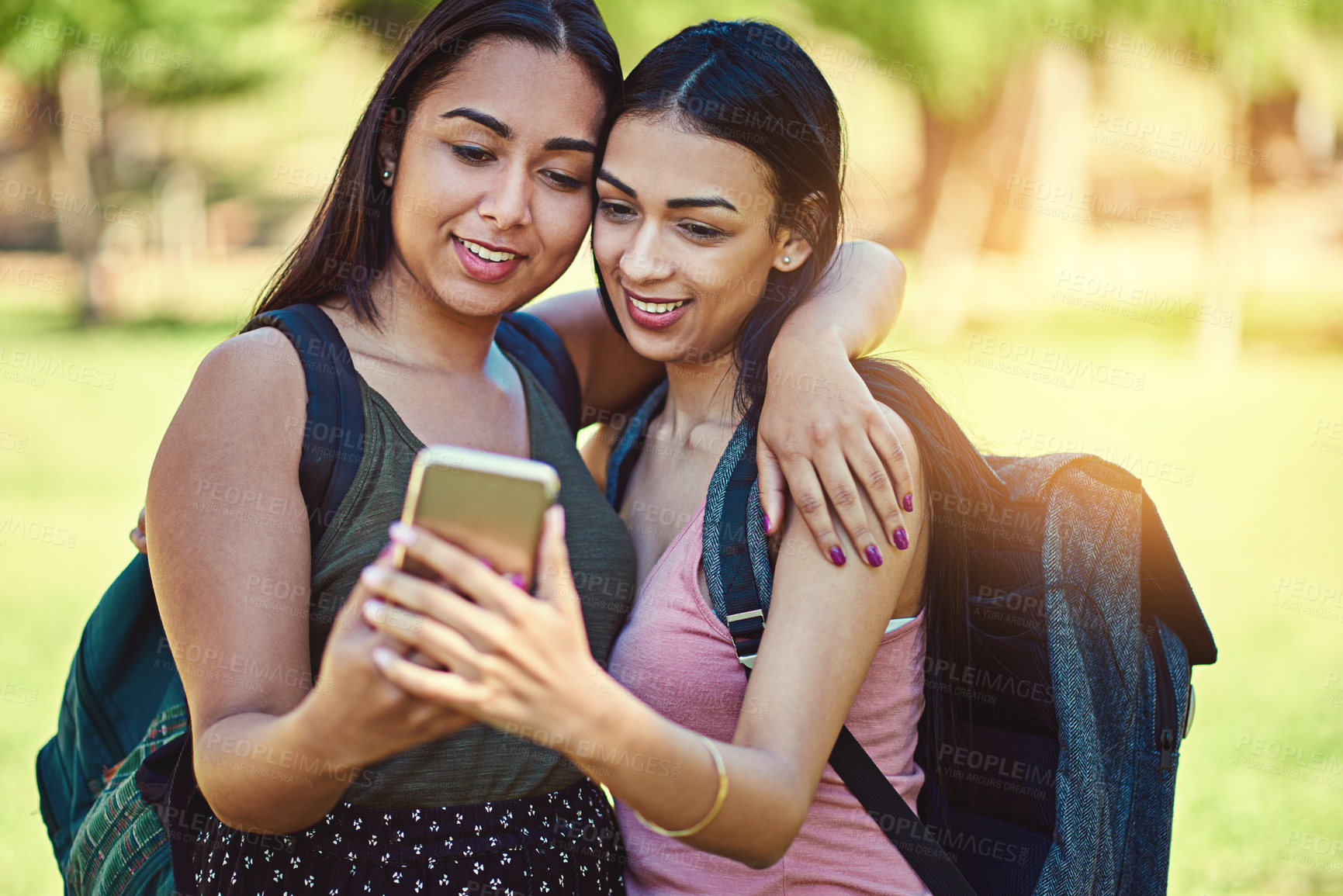 Buy stock photo Cropped shot of two young friends taking a selfie together outside