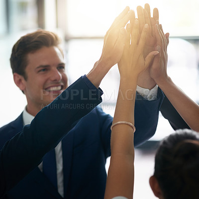 Buy stock photo Cropped shot of a group of businesspeople high fiving together in an office