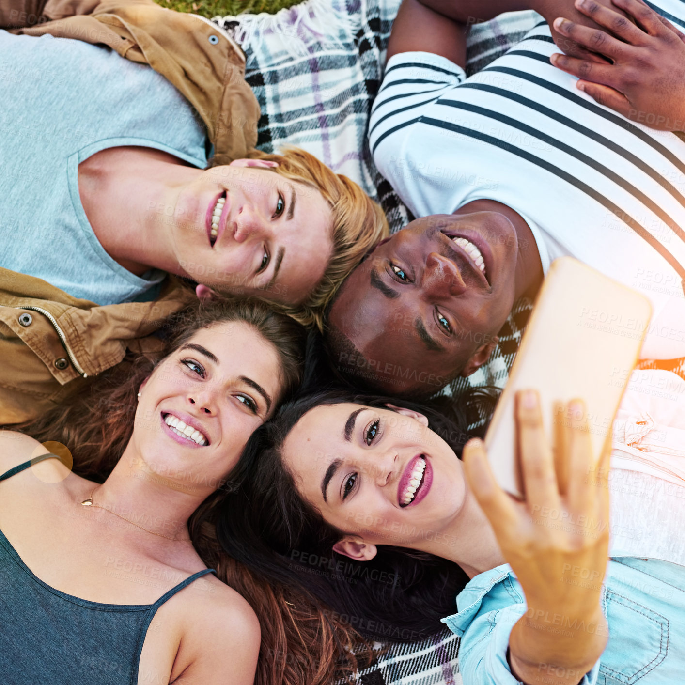 Buy stock photo Friends, top view and outdoor for circle selfie, happiness and diversity for social media post, app or blog. Men, woman and youth for photography, profile picture and bonding while lying on ground