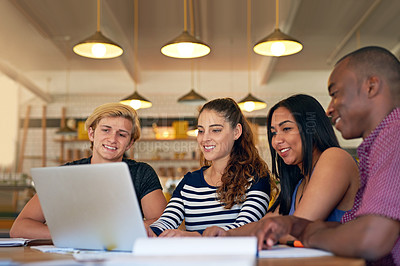 Buy stock photo Shot of a group of young friends using a laptop while studying in a cafe