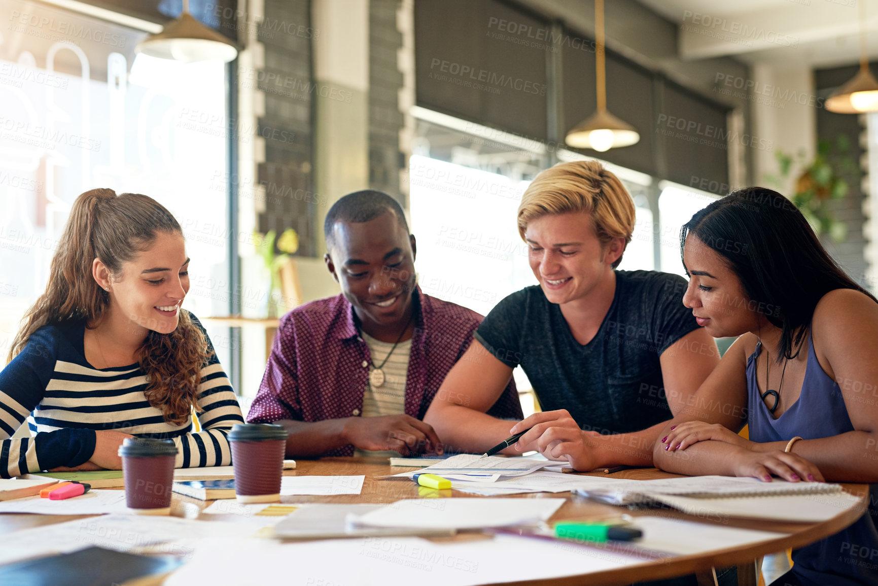 Buy stock photo Shot of a group of young friends having a study session in a cafe