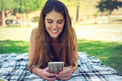 Buy stock photo Blanket, phone and picnic with woman at park in summer for communication, networking or social media. App, face and smile with happy person outdoor on grass with mobile for browsing or text message