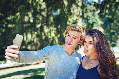 Buy stock photo Couple, selfie and funny face with tongue at park with bonding, outdoor and funny on web at university. Man, women and students for photography, memory and comic with post on social media at college