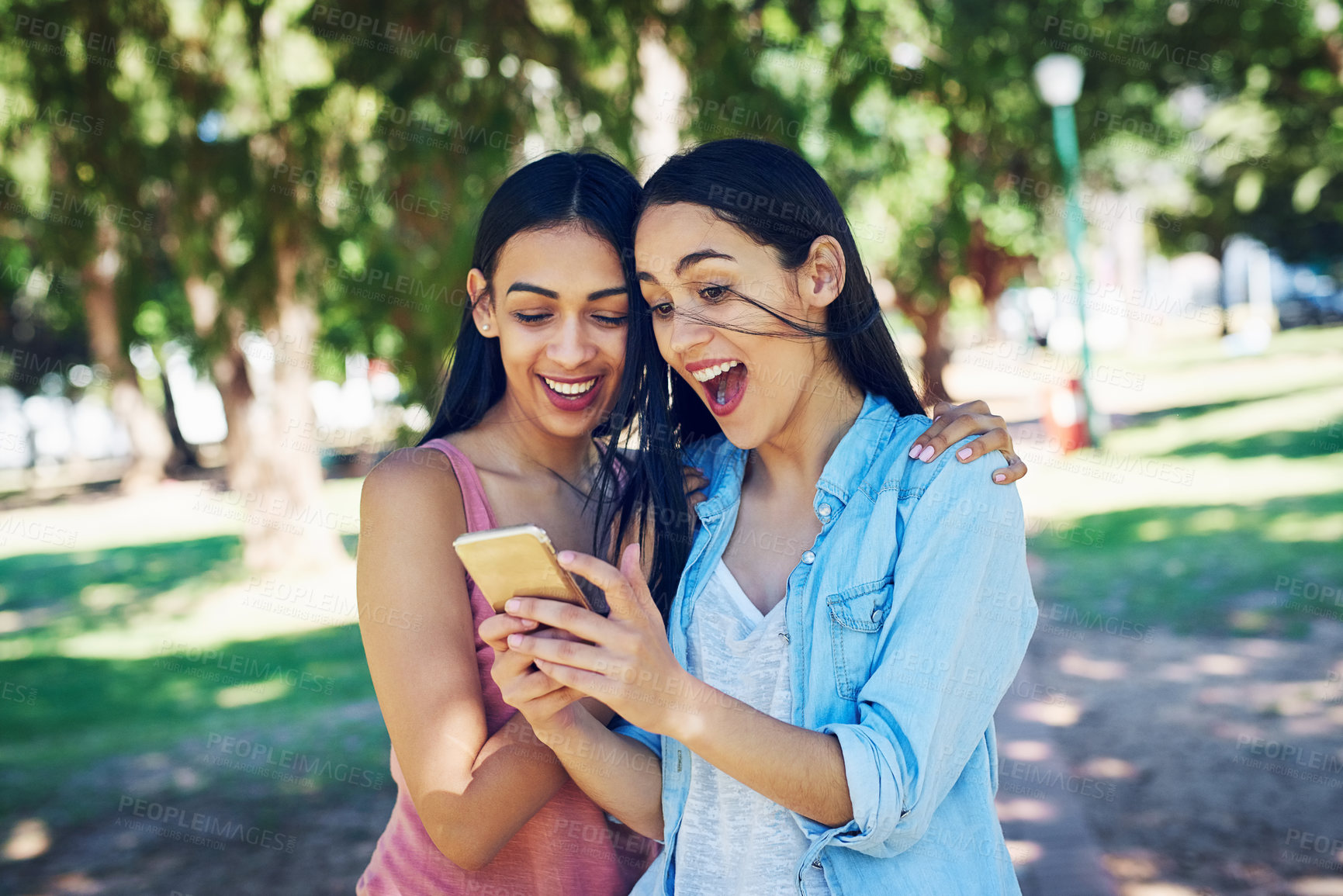 Buy stock photo Women, friends and phone in park with surprise for exam results, email or notification for scholarship. Girl, students and smartphone with hug, support and excited for goals with college assessment