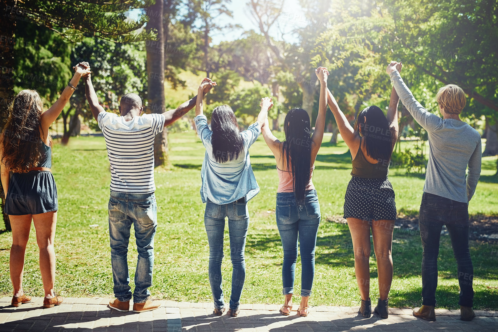 Buy stock photo Friends, celebration and holding hands up at park with solidarity, link and connection for success at college. Women, men and students with support, motivation and cheers for goals at university