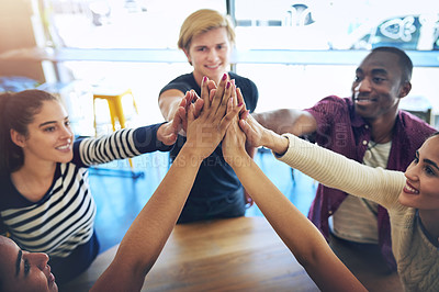 Buy stock photo High angle shot of a group of happy friends high fiving each other