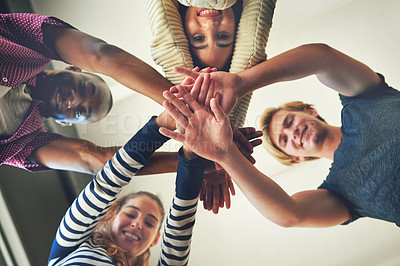 Buy stock photo Low angle portrait of a group of student friends piling their hands on top of each other