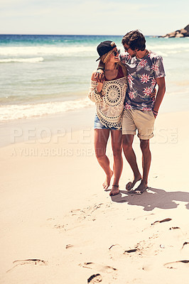 Buy stock photo Full length shot of an affectionate young couple walking on the beach