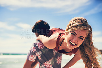Buy stock photo Portrait of an attractive young woman being carried by her boyfriend on the beach