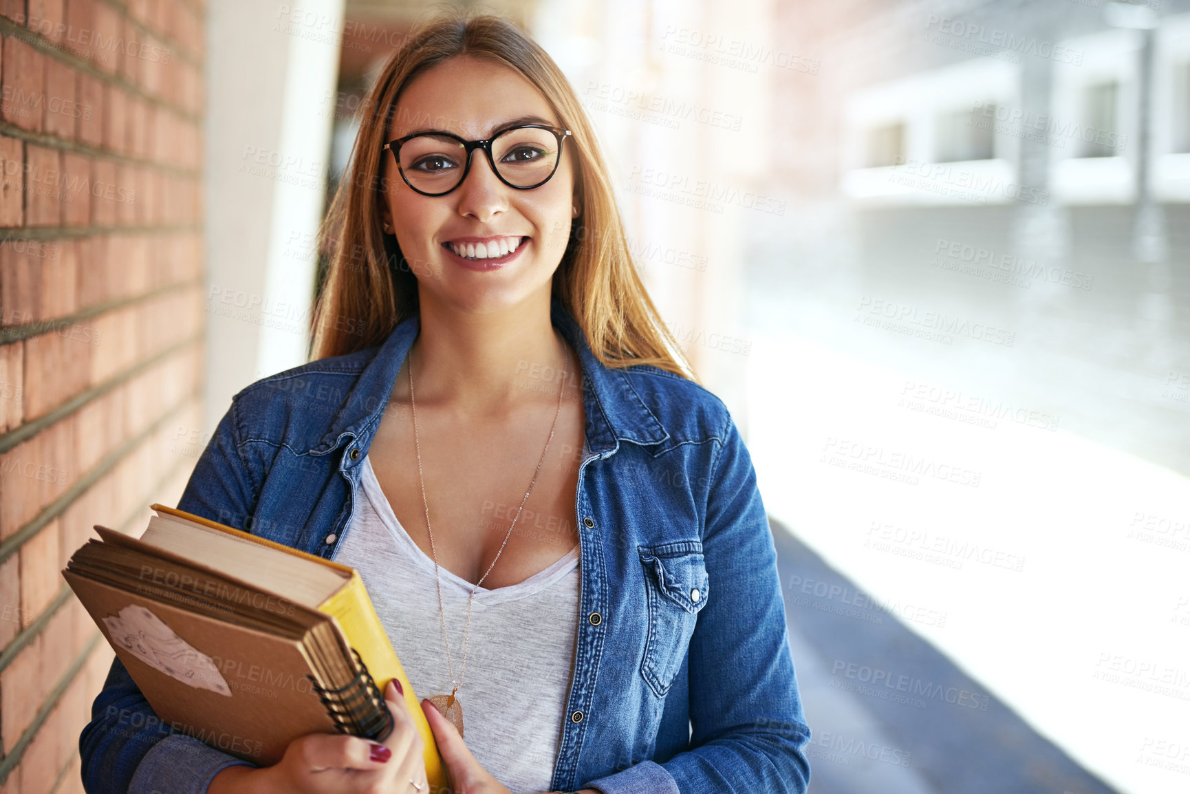 Buy stock photo Portrait of a smiling female university student  standing on campus carrying books
