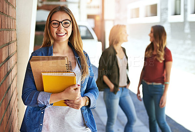 Buy stock photo Portrait of a smiling female university student standing on campus with friends in the background
