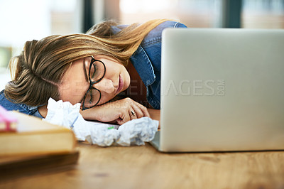 Buy stock photo Shot of a female university student passed out at her laptop while working on homework