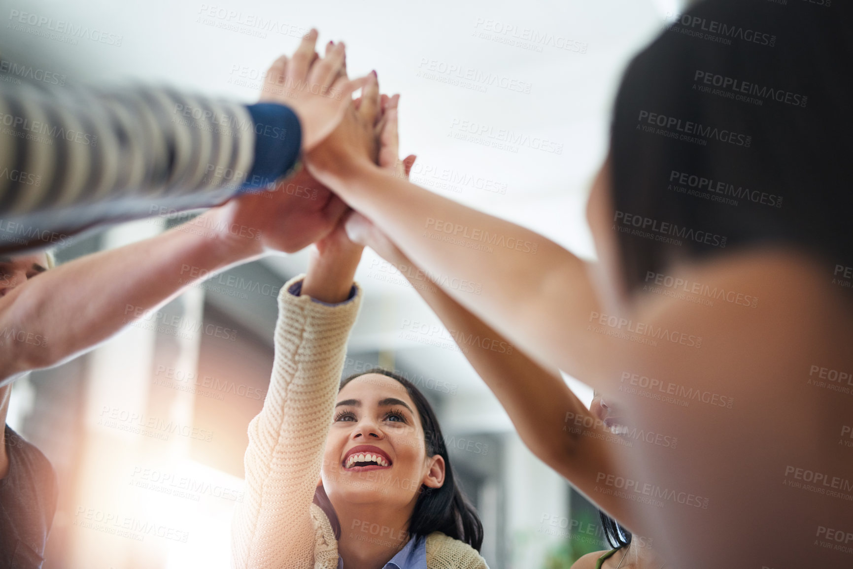 Buy stock photo Shot of a group of happy friends high fiving each other in a cafe