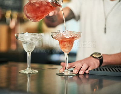 Buy stock photo Cropped shot of an unidentifiable bartender pouring a cocktail behind the bar