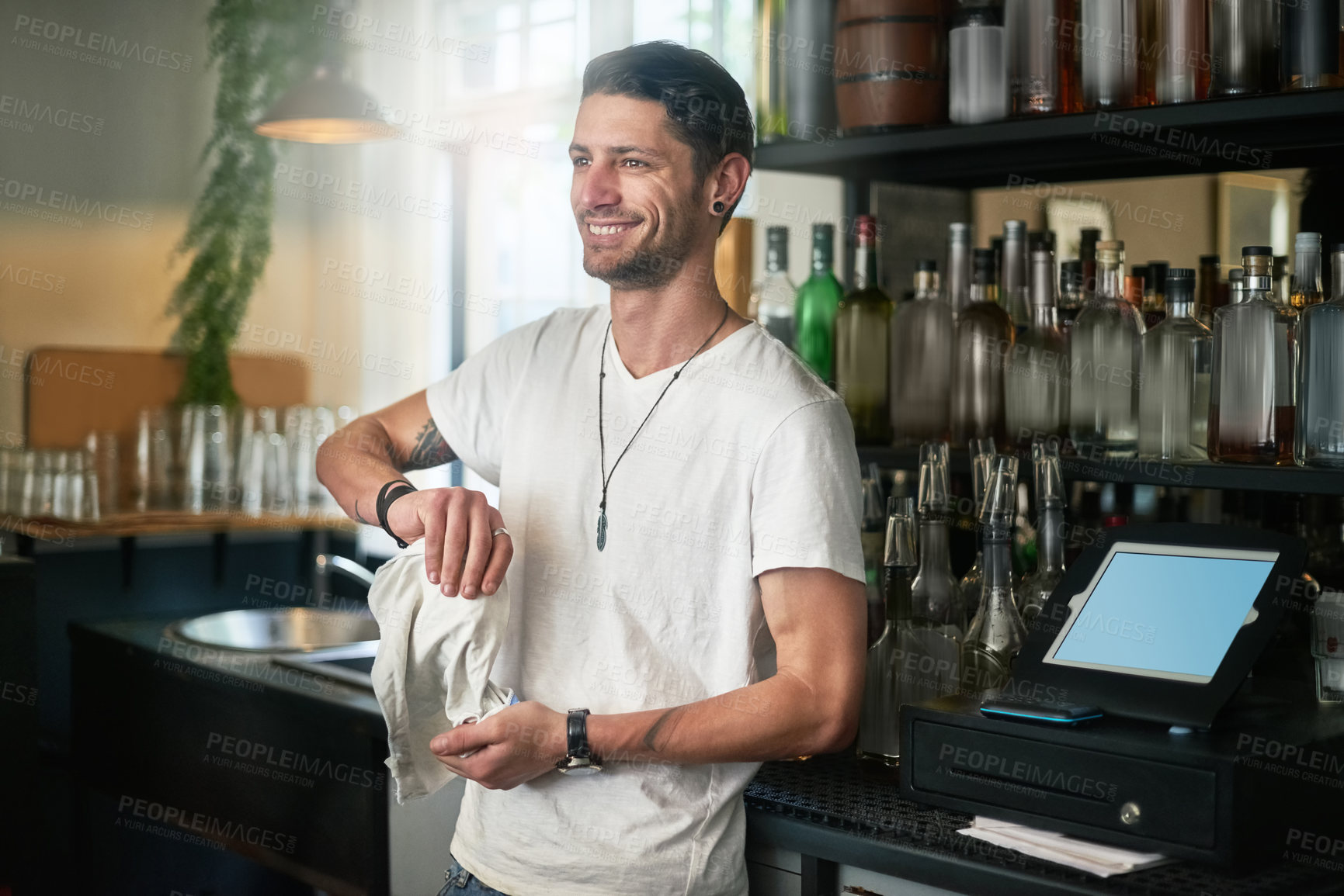 Buy stock photo Waiter, man and cleaning a glass in cafe with smile for daydreaming and wondering with hygiene in small business. Bartender, person and happy in restaurant with polishing, disinfection and pub pride