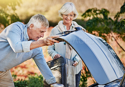 Buy stock photo Shot of a senior couple checking the engine of their convertible while out on a roadtrip