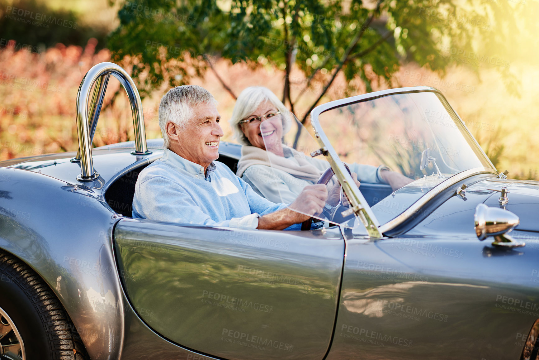 Buy stock photo Shot of a happy senior couple enjoying a roadtrip in a convertible