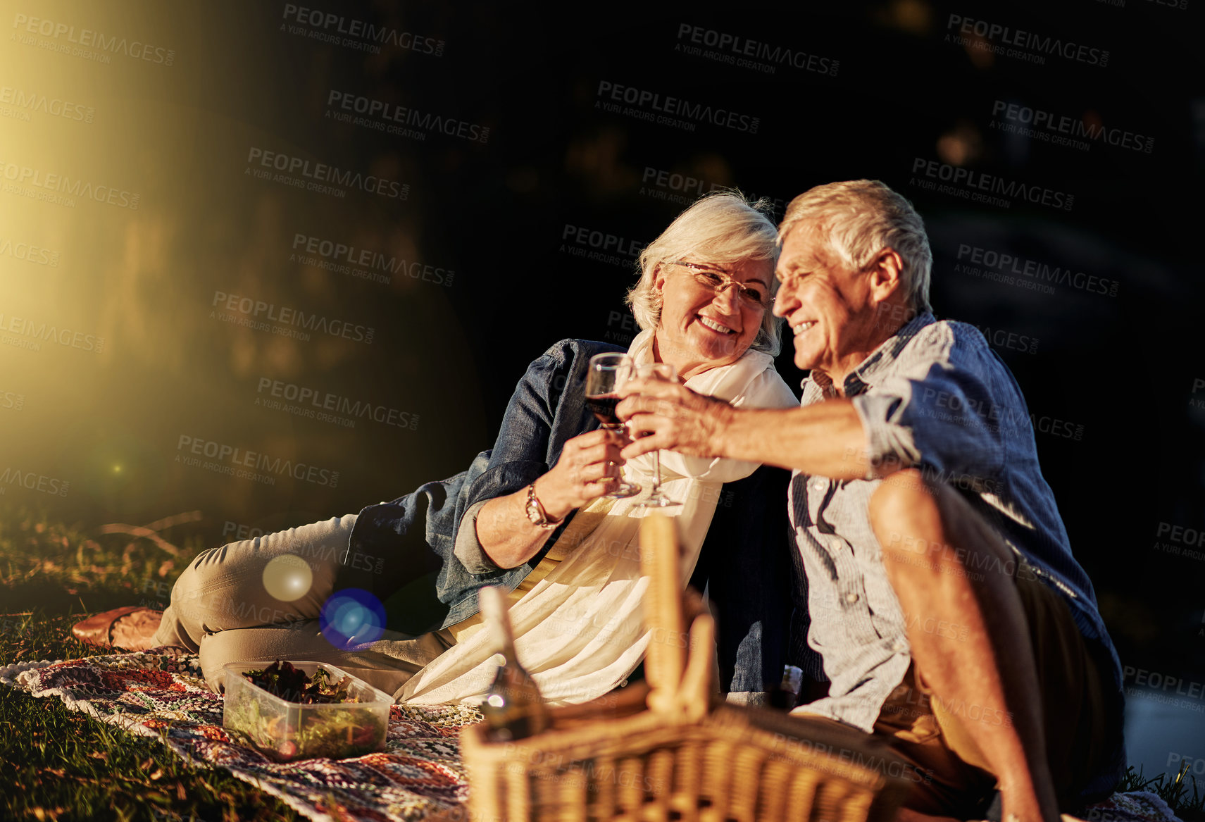 Buy stock photo Senior couple, wine glasses and toast at picnic on travel, romance and relax in outdoor nature. Elderly people, cheers and drink alcohol on vacation, holiday and calm celebration on anniversary