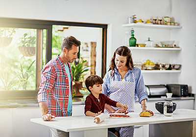 Buy stock photo Shot of a young family making pizza together