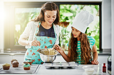 Buy stock photo Shot of a mother and her daughter baking in the kitchen