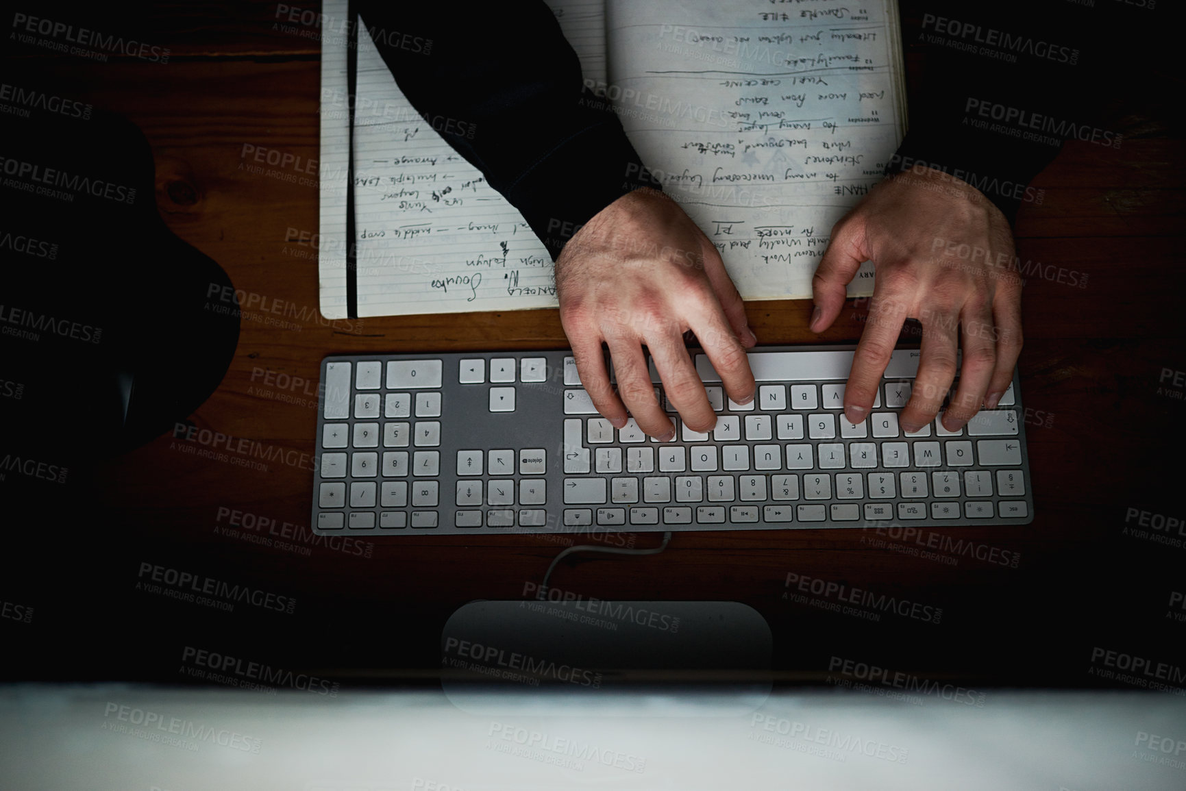 Buy stock photo High angle shot of an unidentifiable hacker using a computer late at night