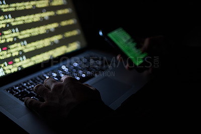 Buy stock photo Cropped shot of an unidentifiable hacker using a laptop late at night