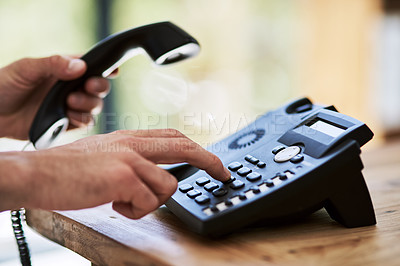 Buy stock photo Cropped shot of a man dialing a number on a telephone at work