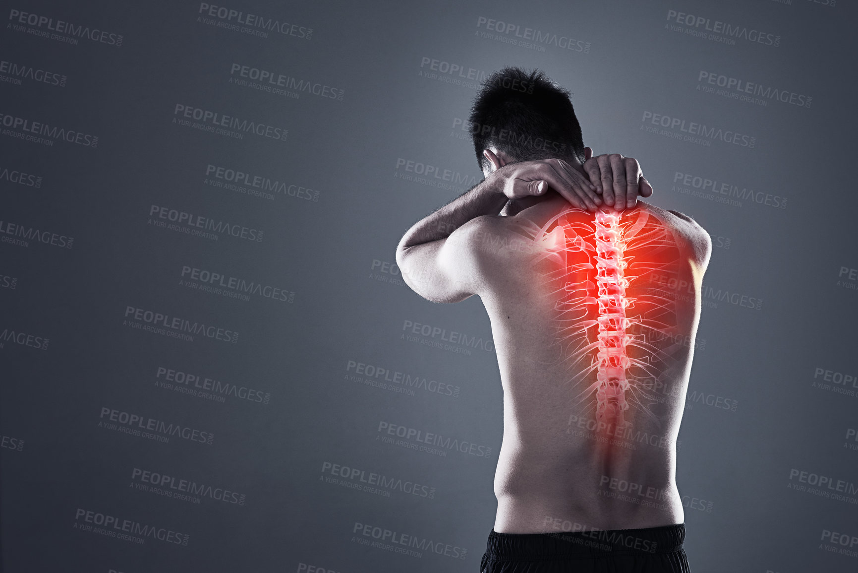 Buy stock photo Rearview shot of a young man in the studio with cgi highlighting his back injury