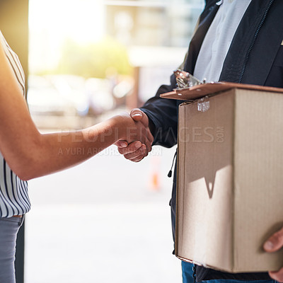 Buy stock photo Cropped shot of a courier shaking hands with a customer during a delivery