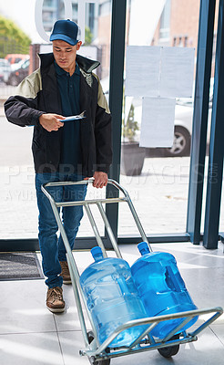 Buy stock photo Shot of a courier making a bottled water delivery in an office