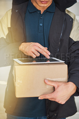 Buy stock photo Cropped shot of a courier using a digital tablet while making a delivery