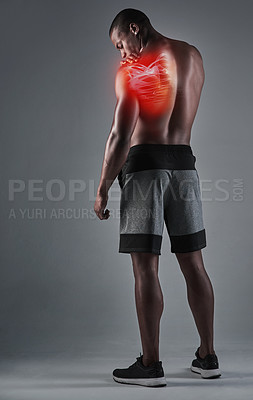 Buy stock photo Rearview shot of an athletic young man with his shoulder injury highlighted