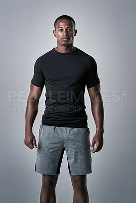 Buy stock photo Studio portrait of an athletic young man standing against a grey background
