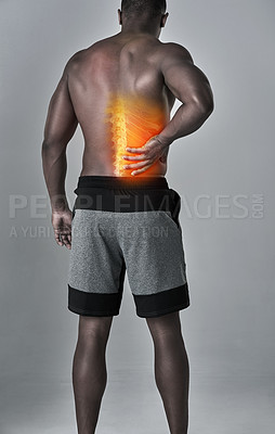 Buy stock photo Rearview shot of an athletic young man holding his lower back in pain