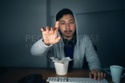 Buy stock photo Shot of a young man using an unseen digital interface while sitting at a computer late at night