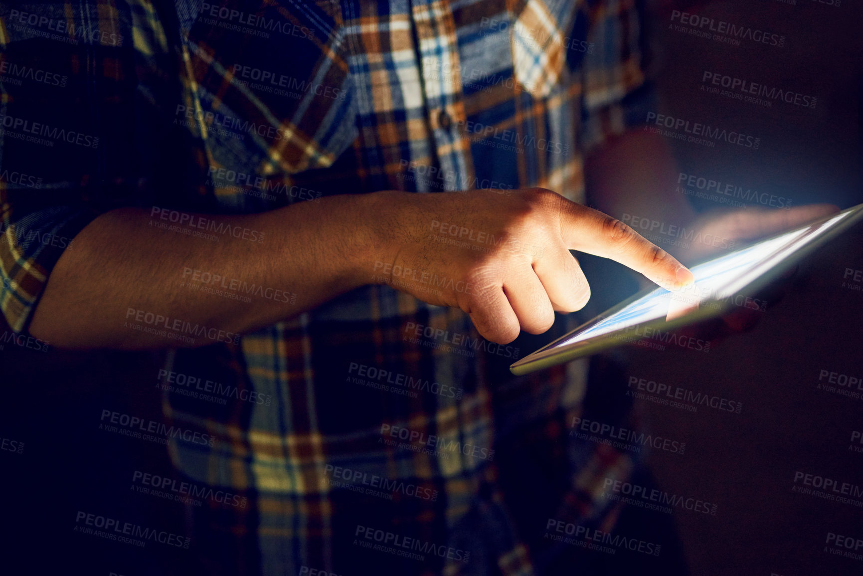 Buy stock photo Cropped shot of a male designer working on a digital tablet late in the office