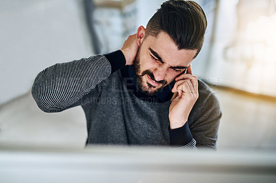 Buy stock photo Shot of a young designer looking stressed out while talking on a cellphone in an office