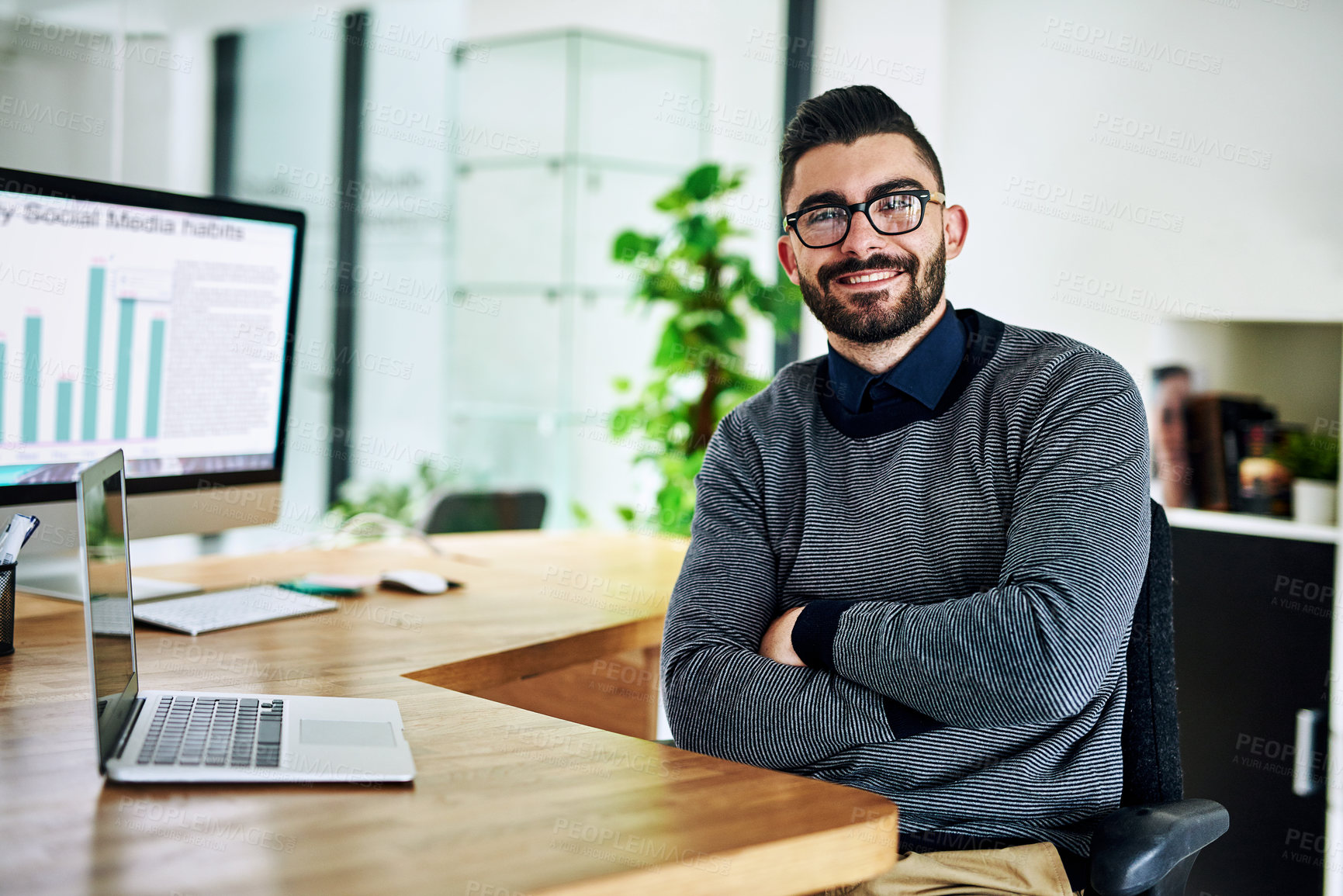 Buy stock photo Portrait of a confident young designer sitting at his desk in an office