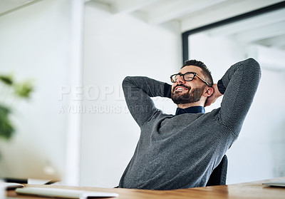 Buy stock photo Shot of a young designer taking a break at his office desk