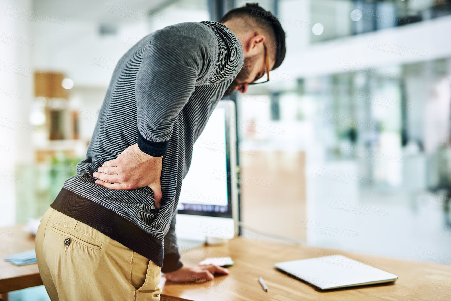 Buy stock photo Back pain, business man and social media worker with strain, stress and anxiety by a computer in office. Tech, web and working with online, digital and internet project with work problem at company
