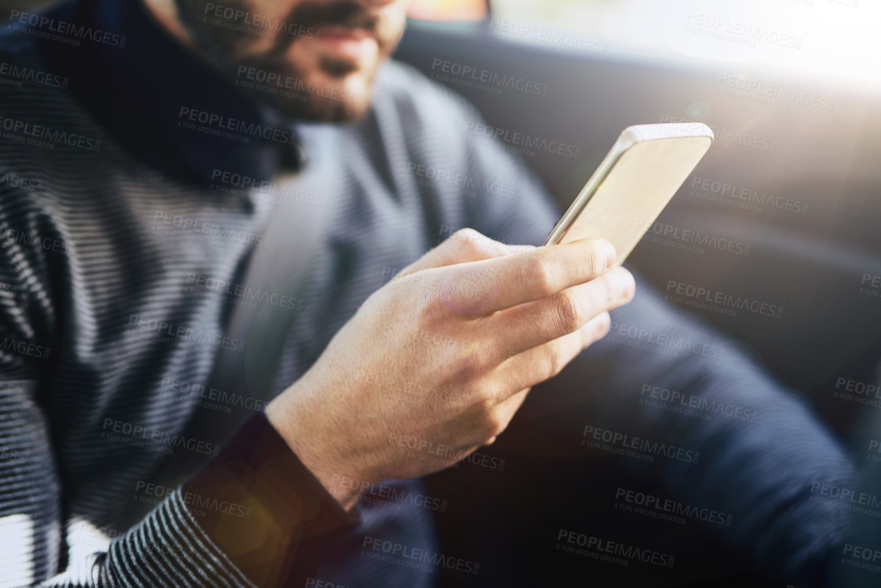 Buy stock photo Closeup shot of an unrecognisable man using a cellphone in a car