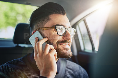 Buy stock photo Shot of a young man talking on a cellphone in a car