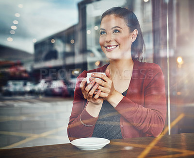 Buy stock photo Cropped shot of an attractive young woman enjoying a cup of coffee in a cafe