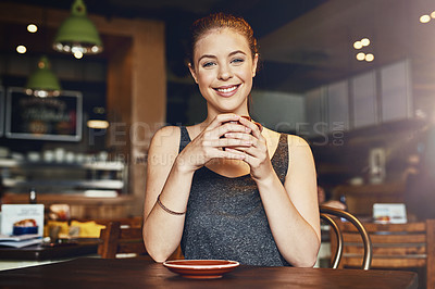 Buy stock photo Cropped shot of a young woman having a cup of coffee in a cafe