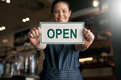 Buy stock photo Portrait of a young woman holding up an open sign in her store