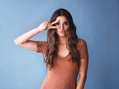Buy stock photo Shot of an expressive young woman posing against a colorful background
