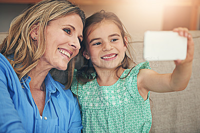 Buy stock photo Happy mom, daughter and relax with selfie on sofa for picture, memory or bonding together at home. Mother, child or kid with smile for photography, capture or moment on living room couch at house